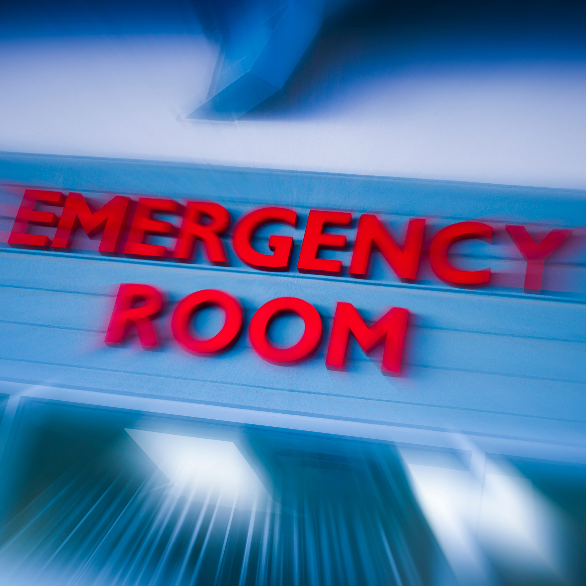 Blurred photo of an emergency room sign (red letters on a blue background)