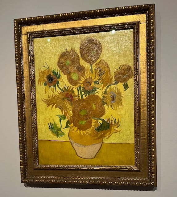 Photo of Vincent van Gogh's painting "Sunflowers" depicting bright yellow sunflowers in a vase.