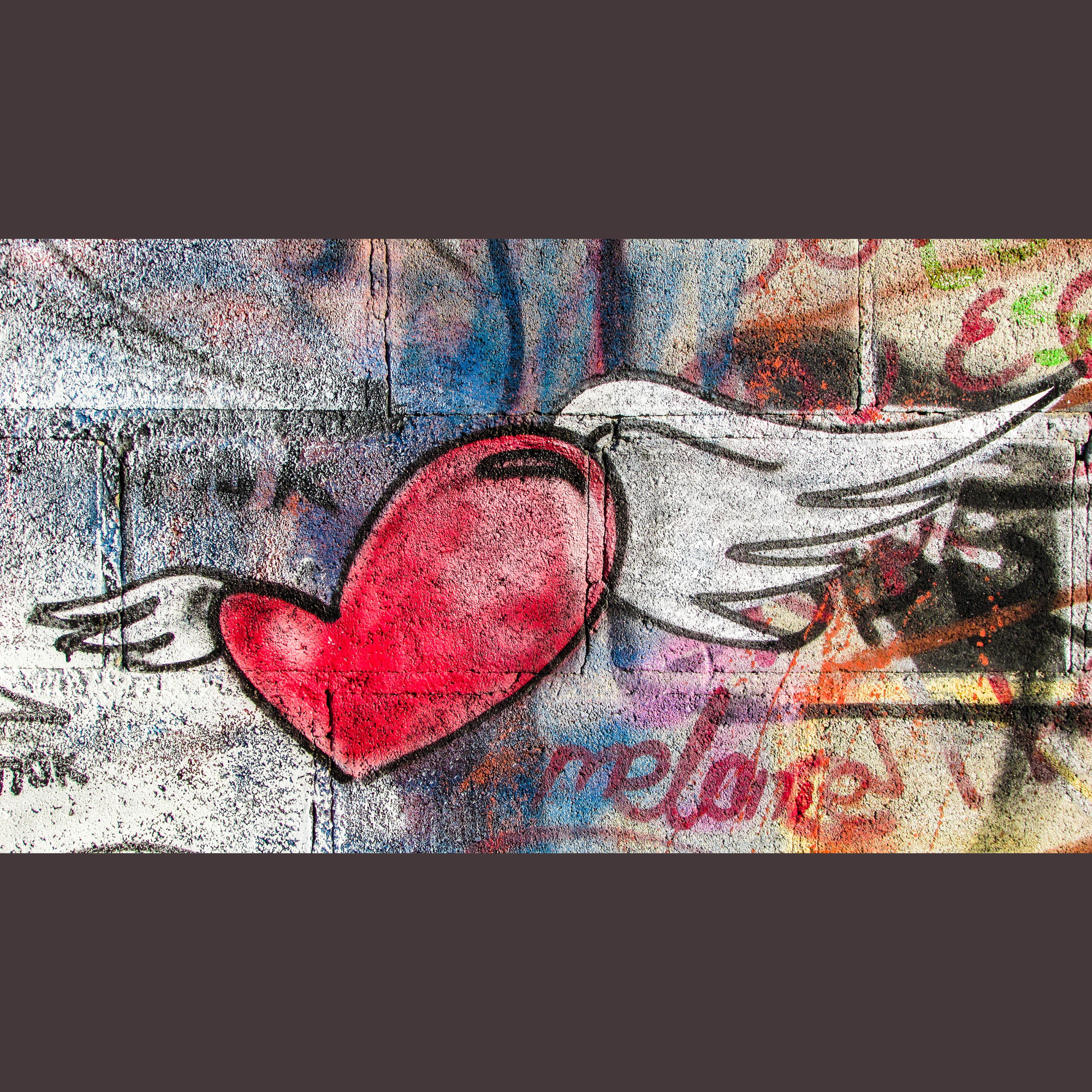 Street art depicting a red heart with white wings