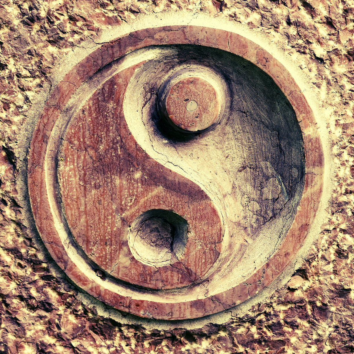 Photo of a yin-yang symbol carved in wood.
