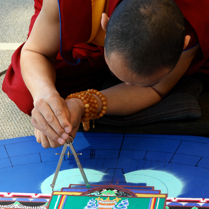 Photo of a Tibetan monk making a sand mandala.